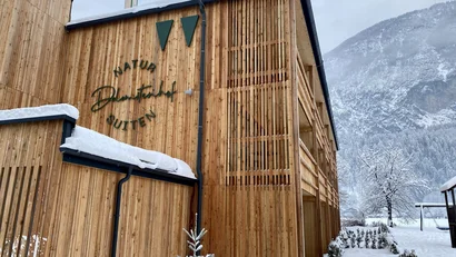 Holzfassade der Natura Suites im verschneiten Bergtal